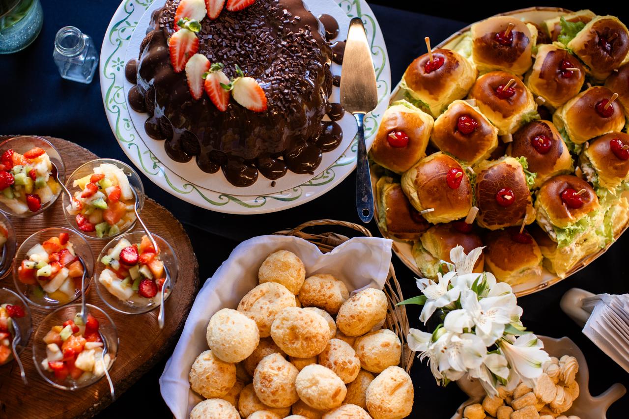 Bolo de chocolate com morangos, pães de queijo e salada de frutas