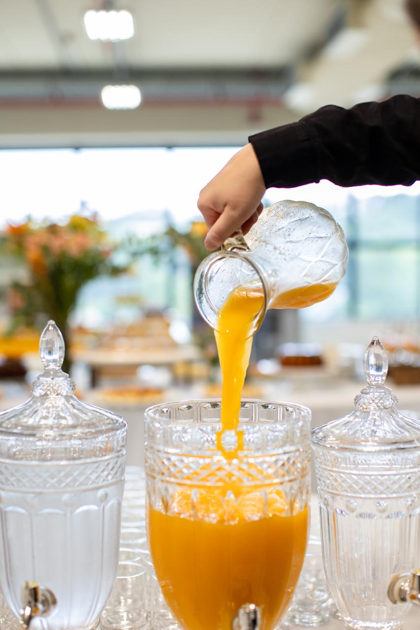 Suco de laranja sendo servido no coffee break